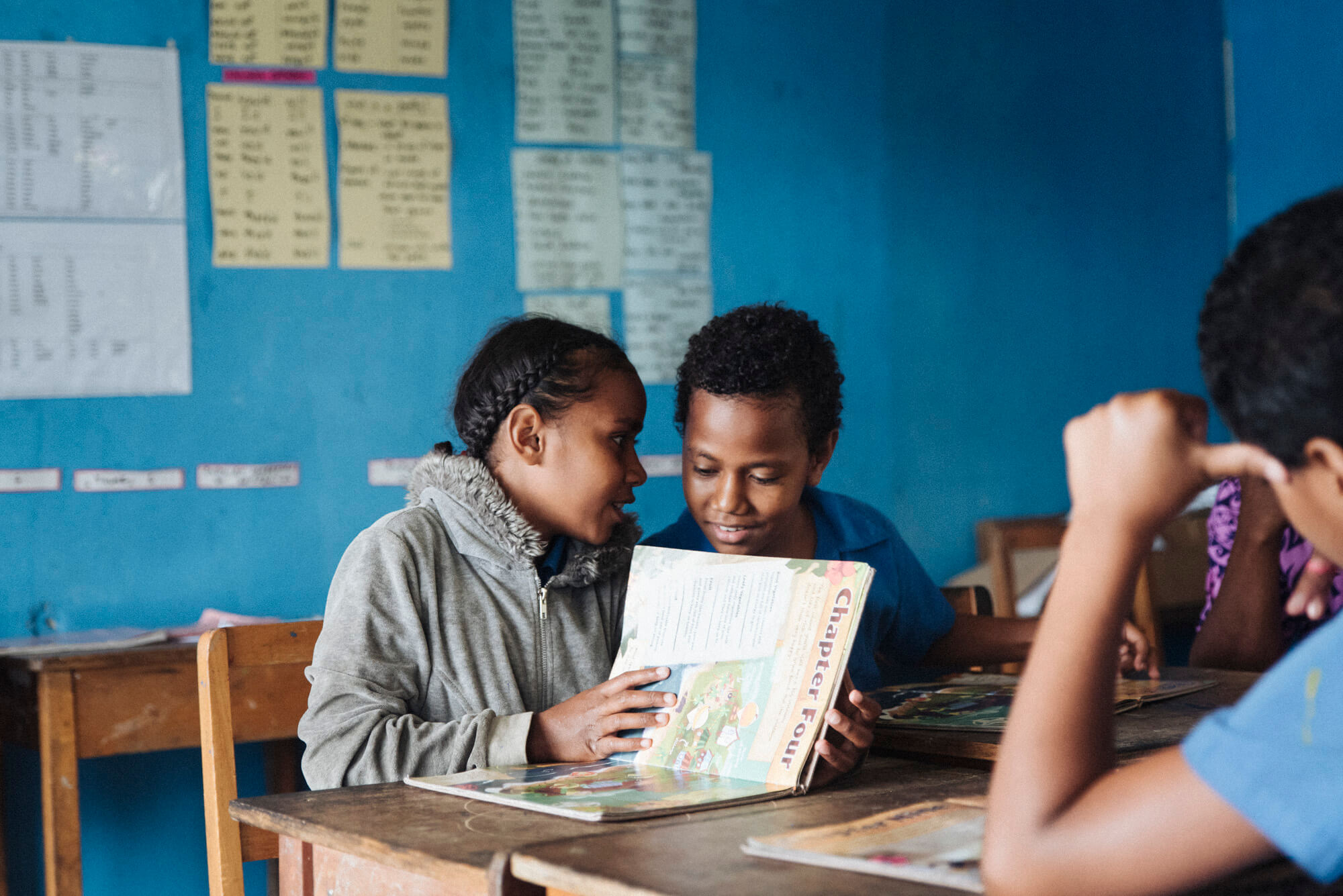 Two Fijian students read the Beyond the Stars educational storybook during class.