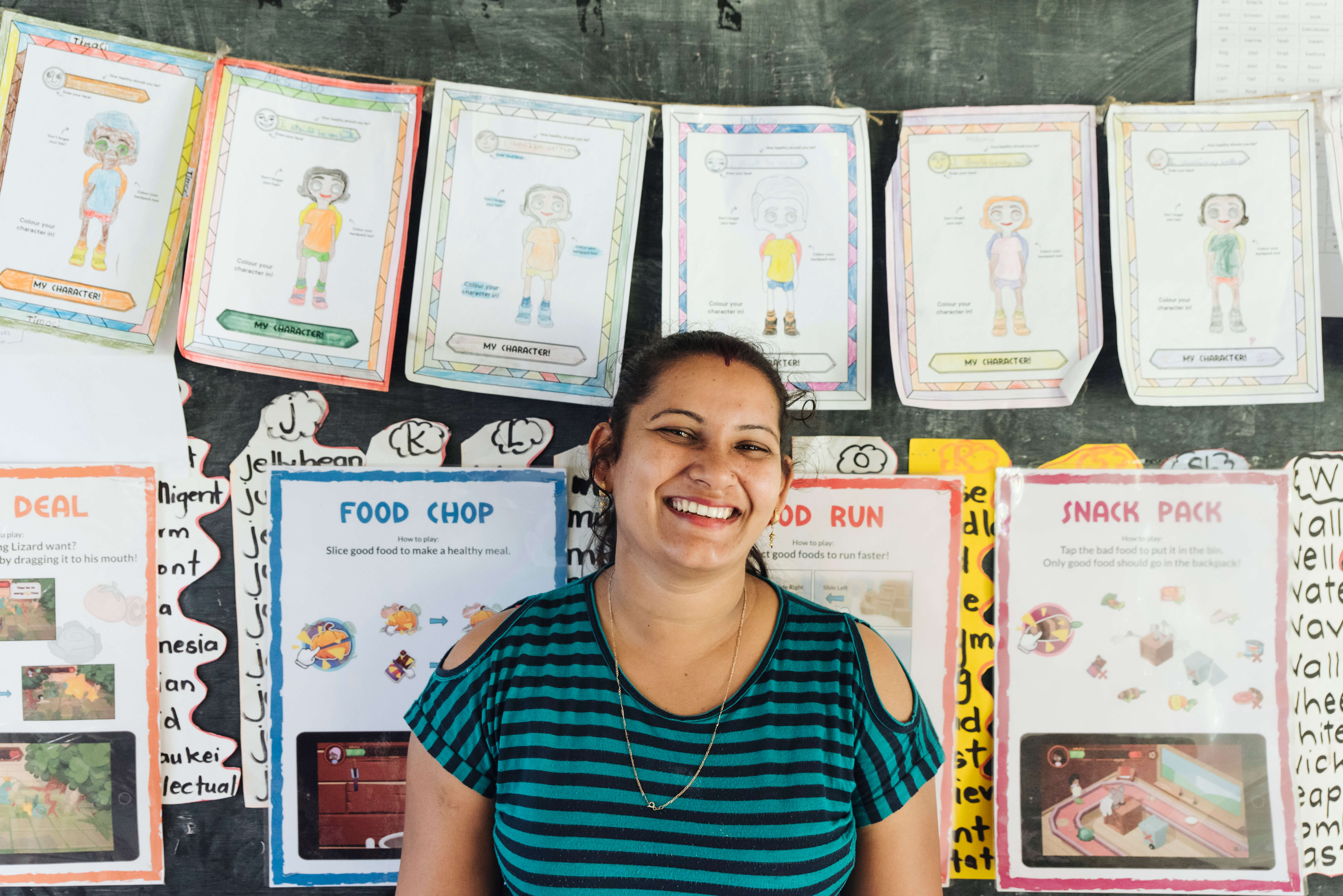 A participating teacher from Namosi, Fiji stands in front of completed Beyond the Stars worksheets in her classroom.