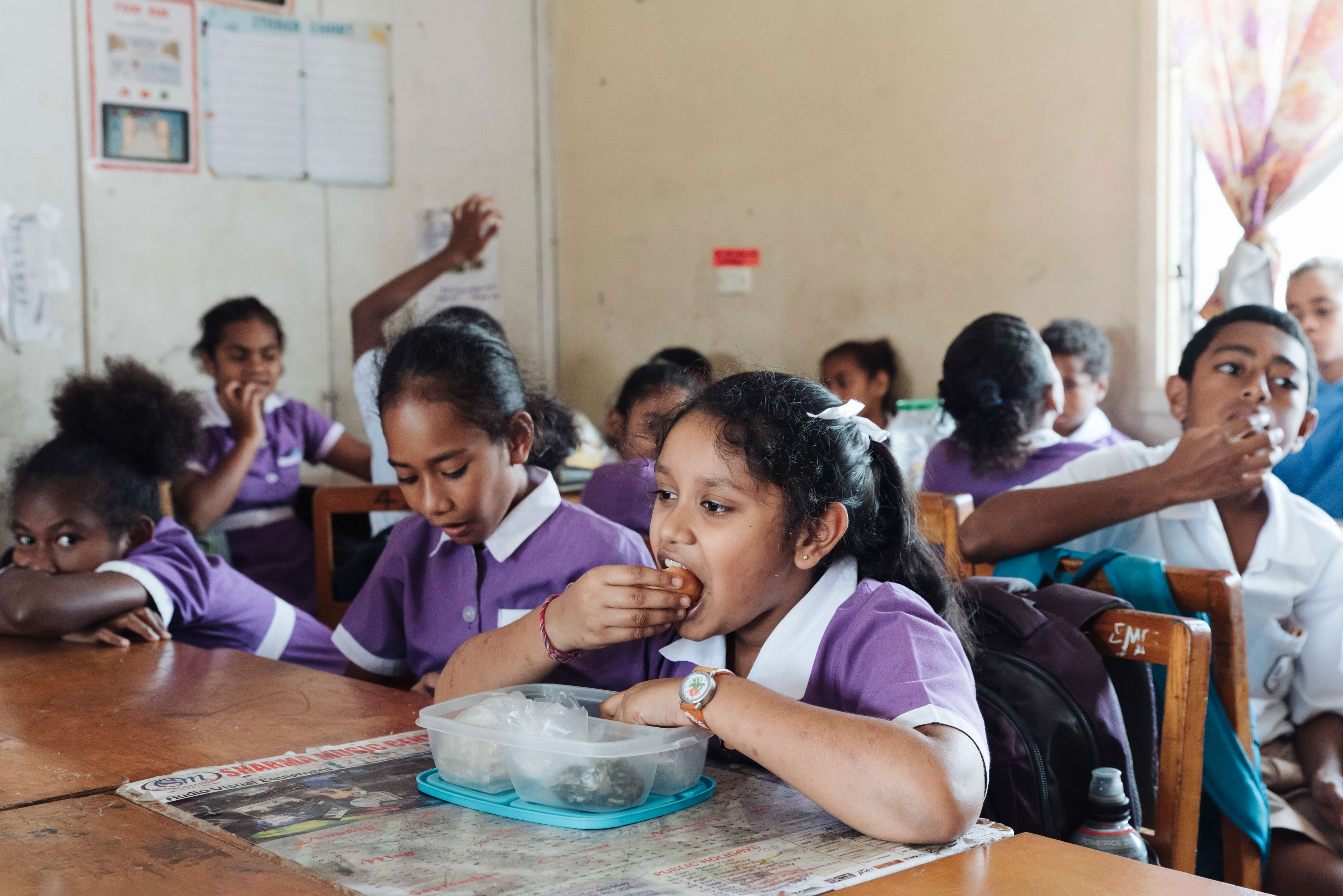 Two Fijian children look through the Beyond the Stars storybook.