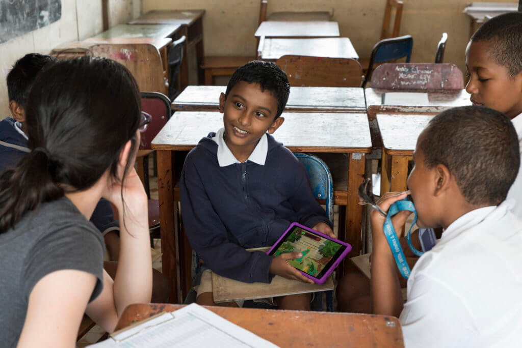 A Fijian child describes the Beyond the Stars mobile game to program coordinators