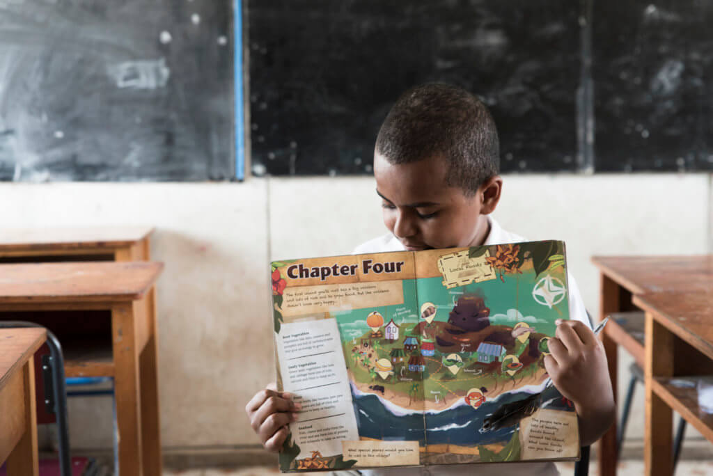 Fijian student looks at the Beyond the Stars storybook at school