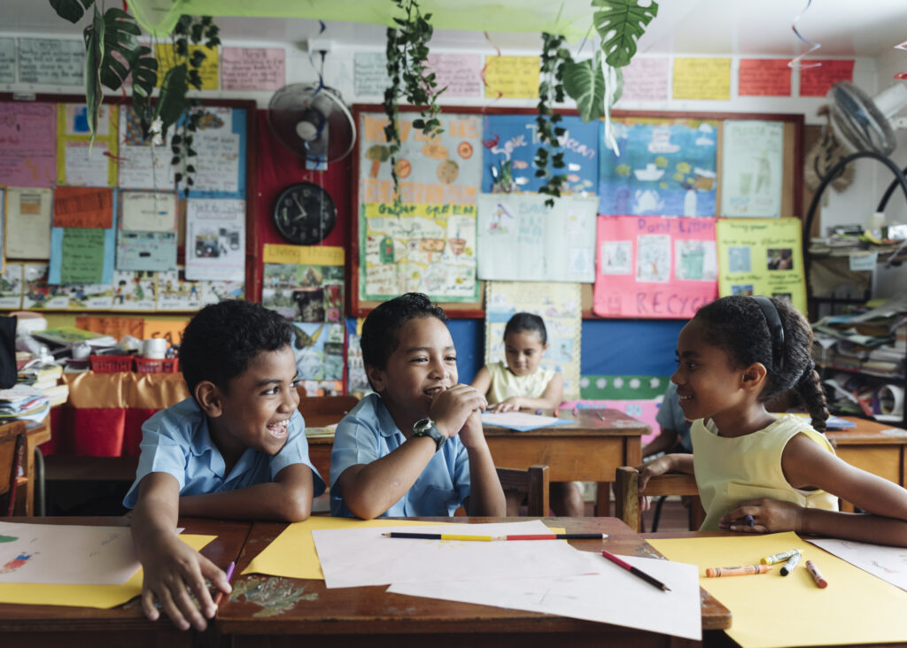 Three children play in a classroom in Fiji