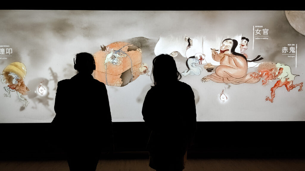 Silhouettes of two people stand in front of S1T2’s interactive touch wall for the Art Gallery of NSW’s Japan Supernatural exhibition