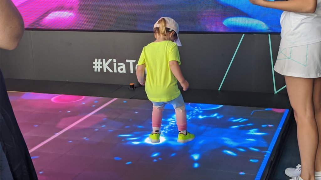 Small child interacts with LED floor of Kia Beat the Beat at the Australian Open.
